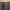 Ein Fahrrad steht auf einem hölzernen Steg am Strand bei Sonnenuntergang; im Hintergrund laufen ein paar Menschen am Meer entlang.