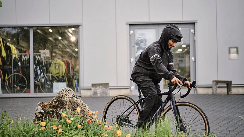JobRadler im Regen mit Grünstreifen auf Vorplatz